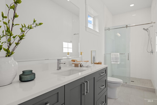 bathroom with vanity, toilet, and a shower with door