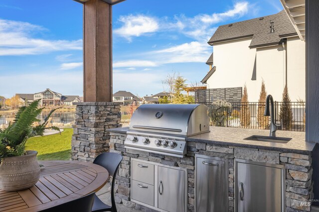 view of patio with an outdoor kitchen, area for grilling, and sink