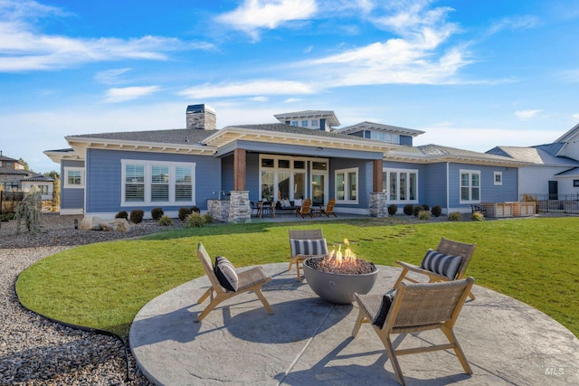 back of house featuring a fire pit, a patio area, and a yard