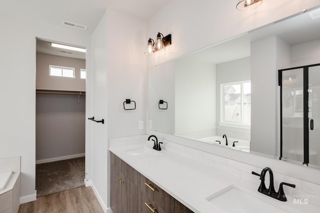 bathroom featuring vanity, separate shower and tub, and hardwood / wood-style floors