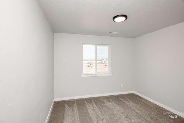 carpeted spare room featuring a textured ceiling