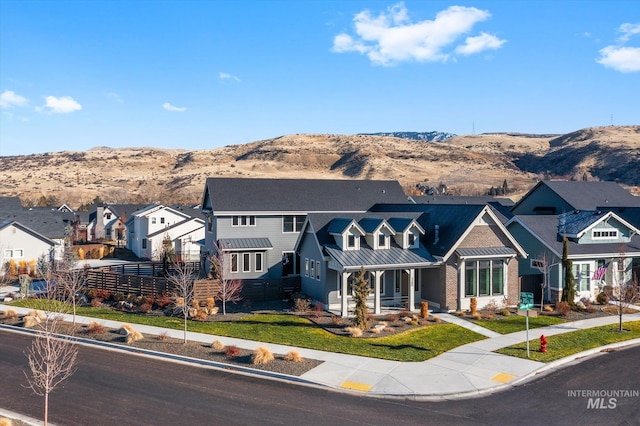 view of front of property with a mountain view and a front lawn