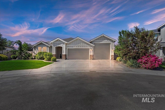 2033 E Whitetail St, Kuna, ID 83634 - view of front of property with board and batten siding, an attached garage, driveway, a front yard, and stone siding