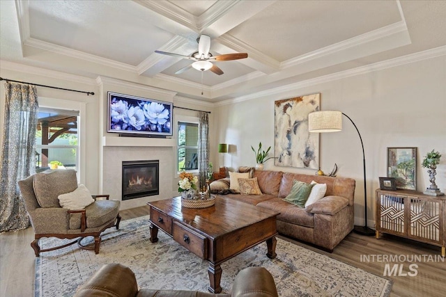 2033 E Whitetail St, Kuna, ID 83634 - living room featuring coffered ceiling, a glass covered fireplace, wood finished floors, a ceiling fan, and beamed ceiling