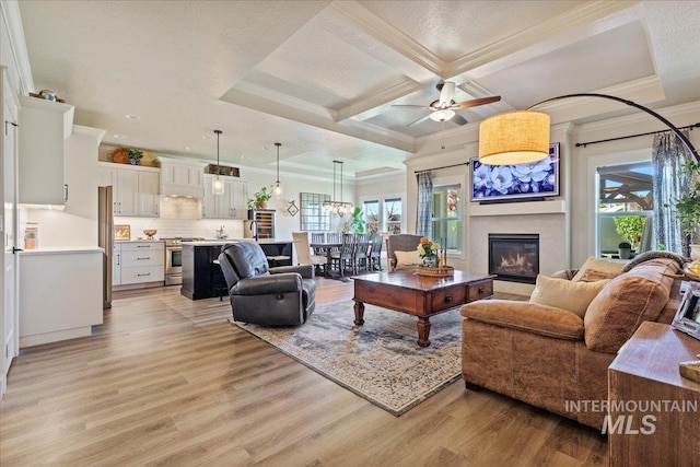 2033 E Whitetail St, Kuna, ID 83634 - living area with light wood-type flooring, a glass covered fireplace, ornamental molding, ceiling fan, and beamed ceiling