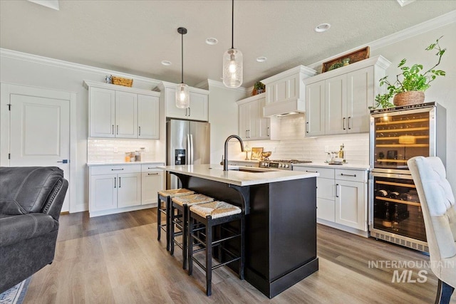 2033 E Whitetail St, Kuna, ID 83634 - kitchen with a sink, ornamental molding, a kitchen bar, stainless steel refrigerator with ice dispenser, and backsplash