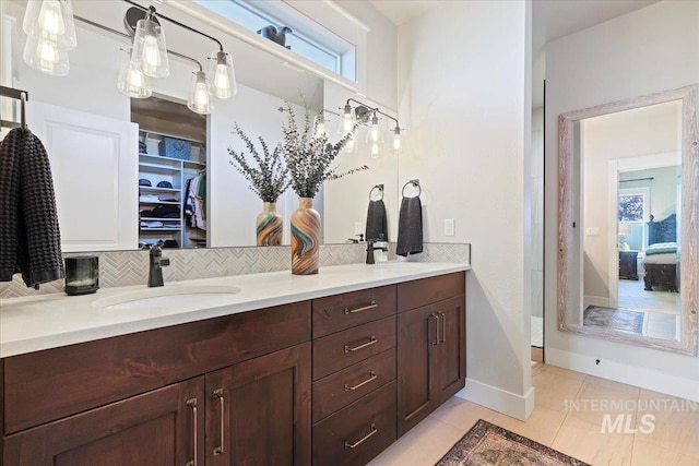 2033 E Whitetail St, Kuna, ID 83634 - full bath featuring double vanity, decorative backsplash, tile patterned floors, baseboards, and ensuite bathroom