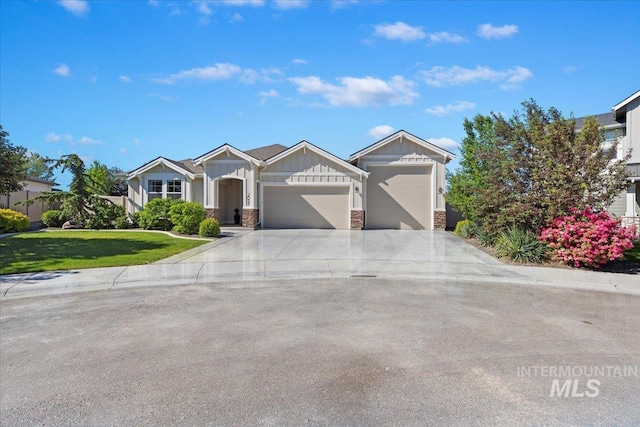 2033 E Whitetail St, Kuna, ID 83634 - view of front of house with board and batten siding, an attached garage, concrete driveway, and stone siding