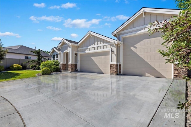 2033 E Whitetail St, Kuna, ID 83634 - view of front of house featuring board and batten siding, an attached garage, stone siding, and driveway