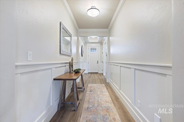 2033 E Whitetail St, Kuna, ID 83634 - entryway with light wood-style floors, crown molding, a decorative wall, and wainscoting