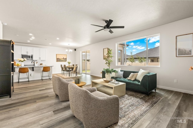 18293 N Begonia Way, Nampa, ID 83687 - living area with recessed lighting, light wood-style flooring, ceiling fan, baseboards, and a chandelier