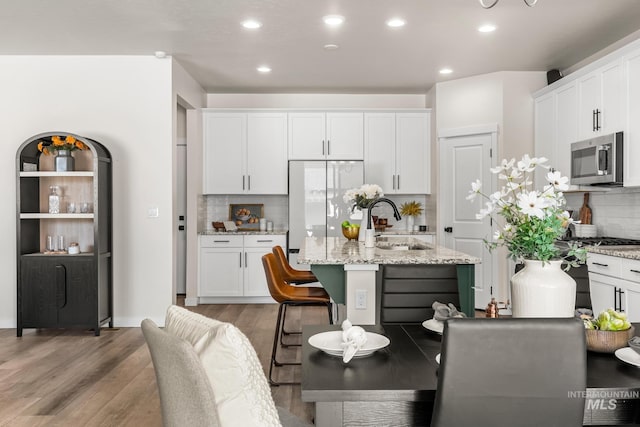 18293 N Begonia Way, Nampa, ID 83687 - kitchen with stainless steel microwave, a sink, backsplash, white cabinets, and recessed lighting
