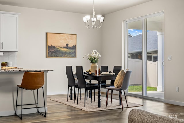 18293 N Begonia Way, Nampa, ID 83687 - dining room featuring healthy amount of natural light, wood finished floors, a chandelier, and baseboards