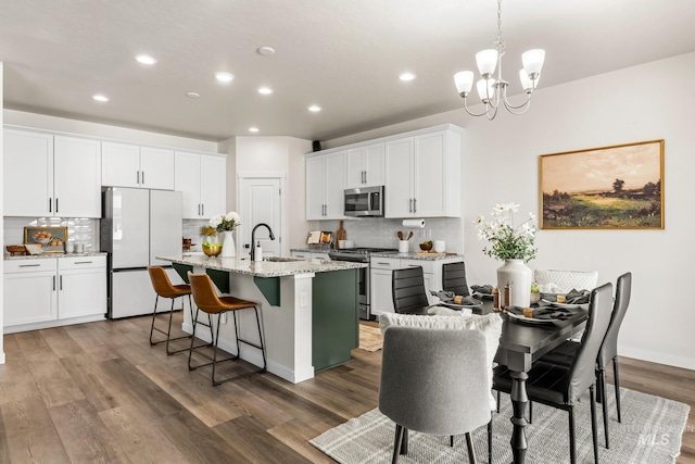 18293 N Begonia Way, Nampa, ID 83687 - kitchen featuring stainless steel appliances, a chandelier, backsplash, recessed lighting, and an island with sink