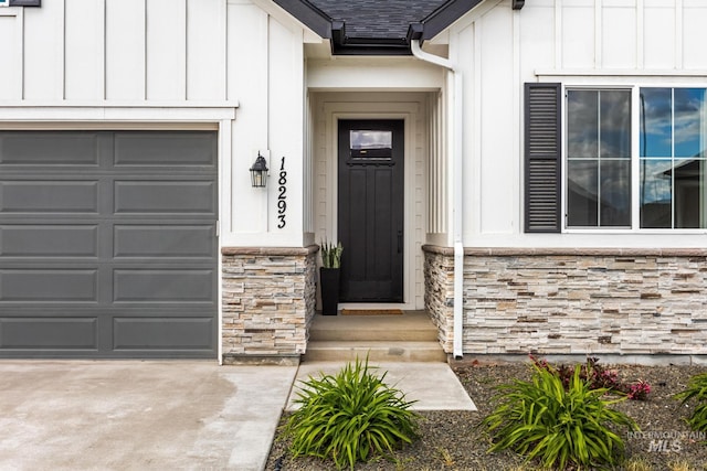 18293 N Begonia Way, Nampa, ID 83687 - view of exterior entry featuring stone siding, board and batten siding, roof with shingles, and a garage