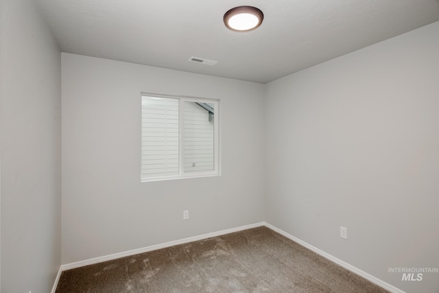 carpeted empty room featuring visible vents and baseboards