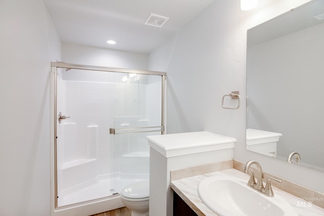 full bathroom featuring toilet, a stall shower, vanity, and visible vents