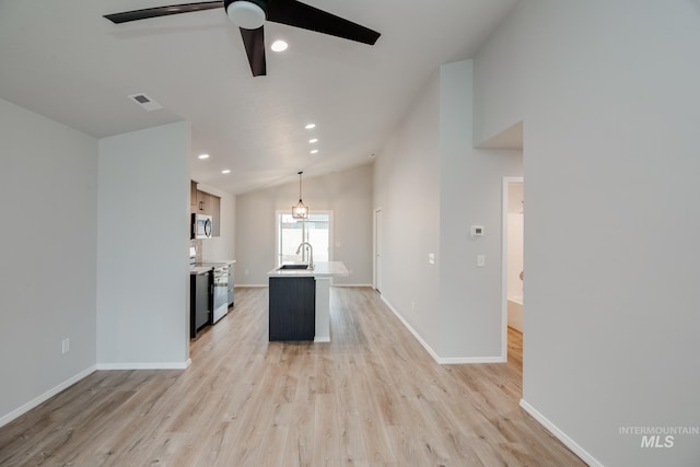 kitchen with electric range, lofted ceiling, light countertops, light wood-type flooring, and a sink