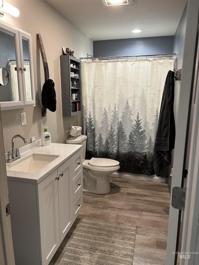 bathroom with hardwood / wood-style flooring, vanity, toilet, and a shower with shower curtain