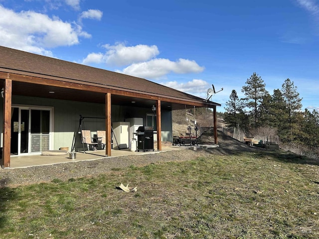 rear view of house with a patio and a lawn