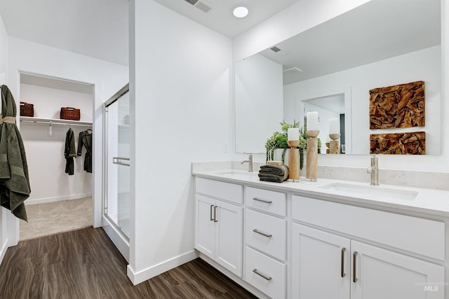 bathroom featuring hardwood / wood-style flooring, vanity, and an enclosed shower