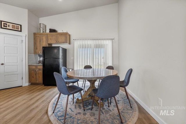 dining room featuring baseboards and light wood-style flooring