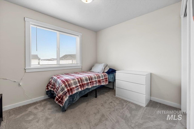 bedroom with baseboards and carpet