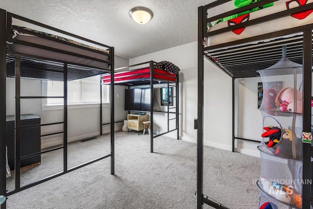bedroom with baseboards, carpet flooring, and a textured ceiling
