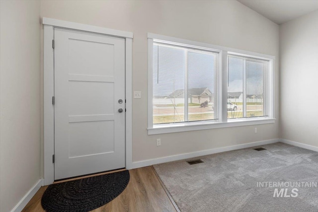 foyer featuring visible vents, baseboards, and a wealth of natural light