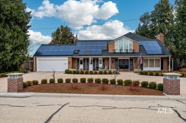 view of front of house featuring an attached garage, covered porch, brick siding, and driveway