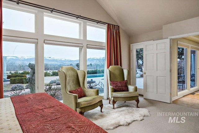 bedroom with lofted ceiling, a mountain view, and light carpet