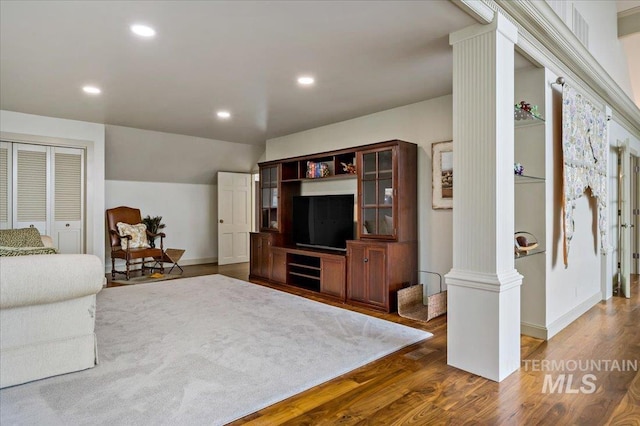 living area featuring baseboards, lofted ceiling, decorative columns, recessed lighting, and dark wood-type flooring