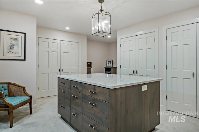 kitchen featuring dark brown cabinets, a center island, light carpet, hanging light fixtures, and a notable chandelier