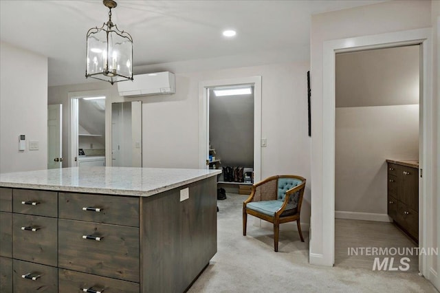 kitchen featuring baseboards, light stone countertops, decorative light fixtures, light colored carpet, and a wall unit AC