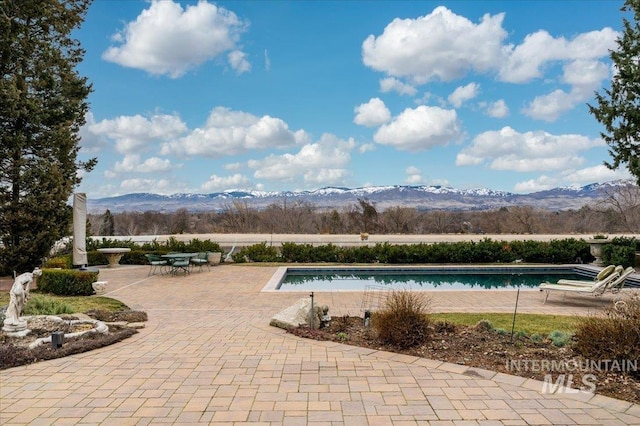 pool with a mountain view and a patio