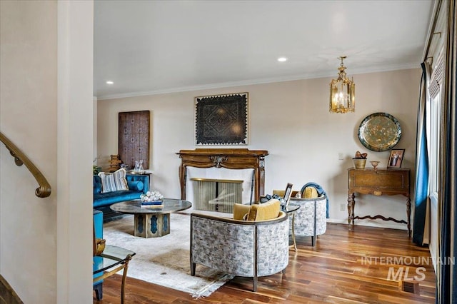 living room with a chandelier, baseboards, wood finished floors, and ornamental molding