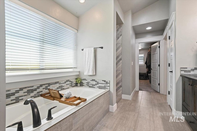 5988 N Lichfield Ave, Meridian, ID 83646 - bathroom with a bath, baseboards, vanity, connected bathroom, and recessed lighting