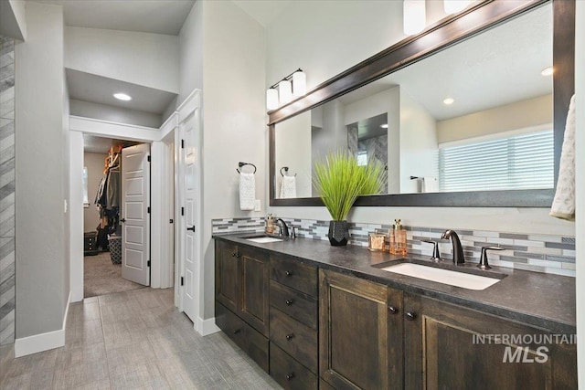5988 N Lichfield Ave, Meridian, ID 83646 - bathroom with double vanity, a sink, backsplash, and a spacious closet