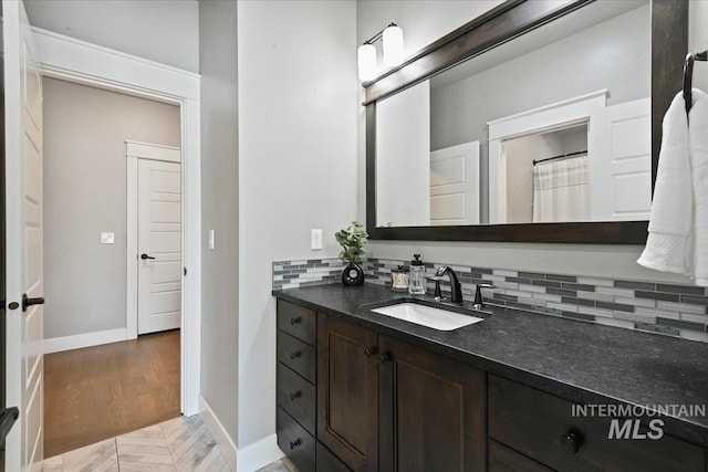 5988 N Lichfield Ave, Meridian, ID 83646 - bathroom featuring vanity, decorative backsplash, and baseboards