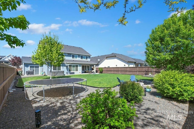 5988 N Lichfield Ave, Meridian, ID 83646 - rear view of house with a fenced backyard, a trampoline, and a yard