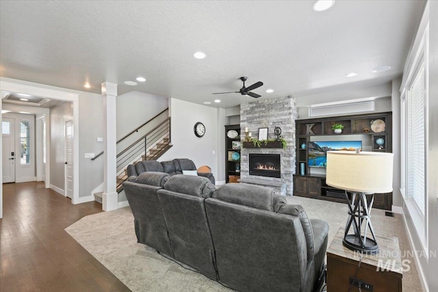 5988 N Lichfield Ave, Meridian, ID 83646 - living room featuring stairs, wood finished floors, a fireplace, baseboards, and a ceiling fan
