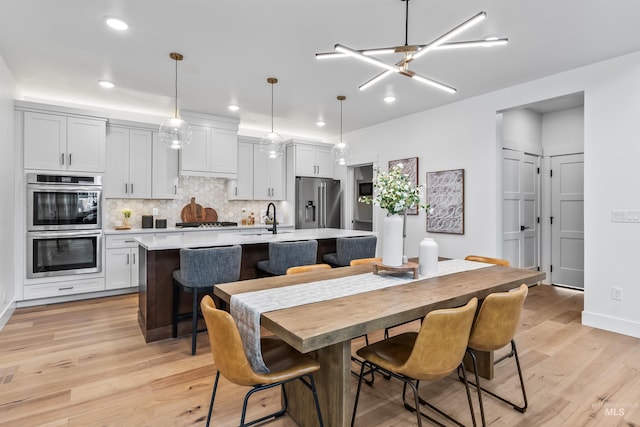 449 S Quincannon Ln, Star, ID 83669 - kitchen with backsplash, pendant lighting, stainless steel appliances, a kitchen island with sink, and white cabinets