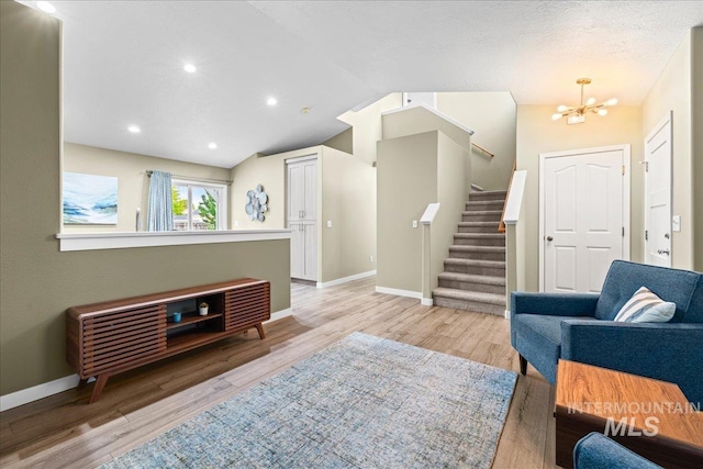 1400 W Florida Ave, Nampa, ID 83686 - living area with baseboards, stairs, light wood finished floors, a chandelier, and vaulted ceiling