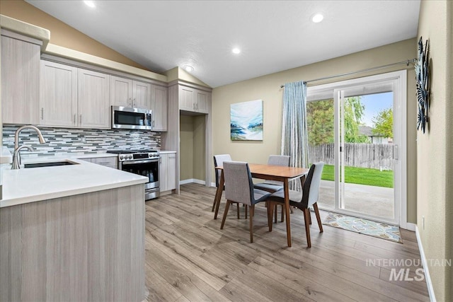 1400 W Florida Ave, Nampa, ID 83686 - kitchen with a sink, appliances with stainless steel finishes, tasteful backsplash, light countertops, and vaulted ceiling