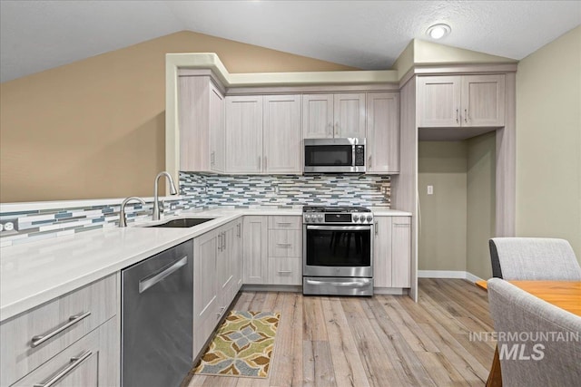 1400 W Florida Ave, Nampa, ID 83686 - kitchen featuring appliances with stainless steel finishes, a sink, lofted ceiling, light countertops, and light wood finished floors