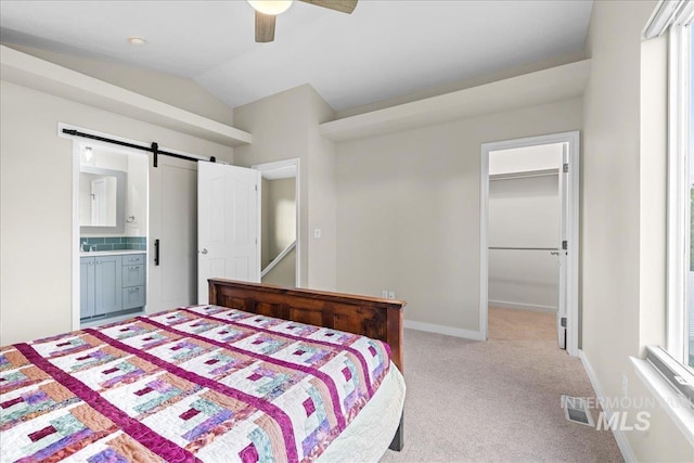 1400 W Florida Ave, Nampa, ID 83686 - bedroom with light colored carpet, a spacious closet, a barn door, vaulted ceiling, and a ceiling fan