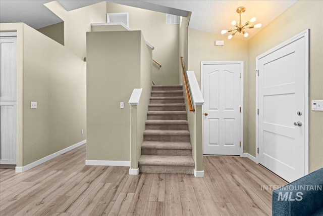 1400 W Florida Ave, Nampa, ID 83686 - foyer entrance featuring light wood finished floors, a chandelier, baseboards, and stairway