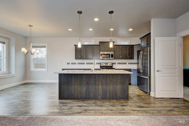 kitchen featuring backsplash, dark brown cabinets, dark wood-type flooring, an inviting chandelier, and stainless steel appliances