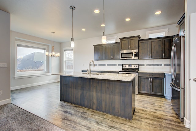 kitchen featuring a sink, stainless steel appliances, light wood-type flooring, and dark brown cabinetry