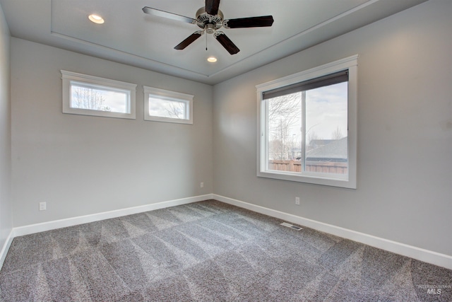 unfurnished room with visible vents, baseboards, carpet, and a ceiling fan